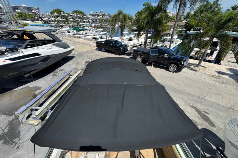 Slide: The Image of 2018 Sea Ray Sundancer 260 docked at marina with trucks and palm trees nearby. - 54