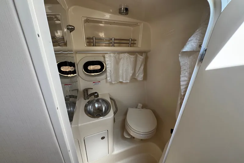 Slide: The Image of 2018 Sea Ray Sundancer 260 bathroom with sink, toilet, and storage shelves. - 47