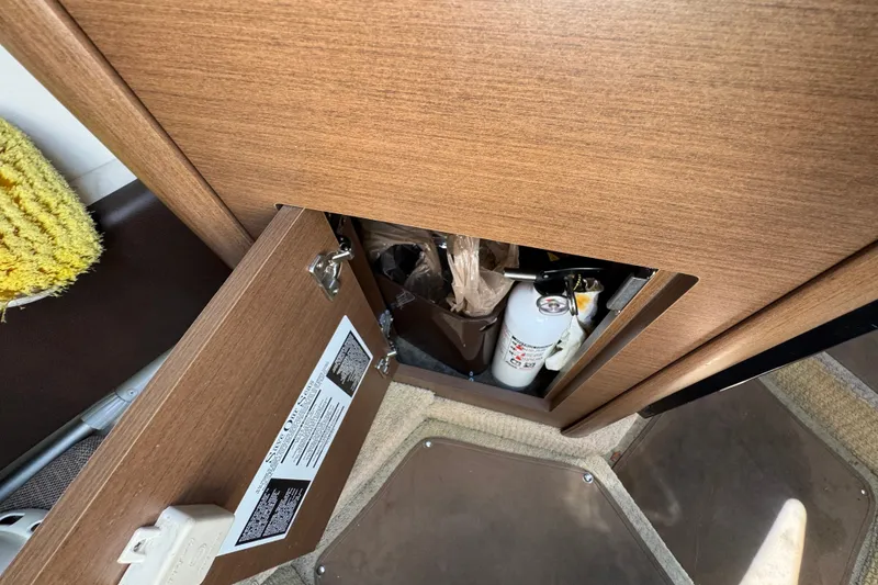 Slide: The Image of Open cabinet on 2018 Sea Ray Sundancer 260 boat, revealing storage with fire extinguisher. - 36