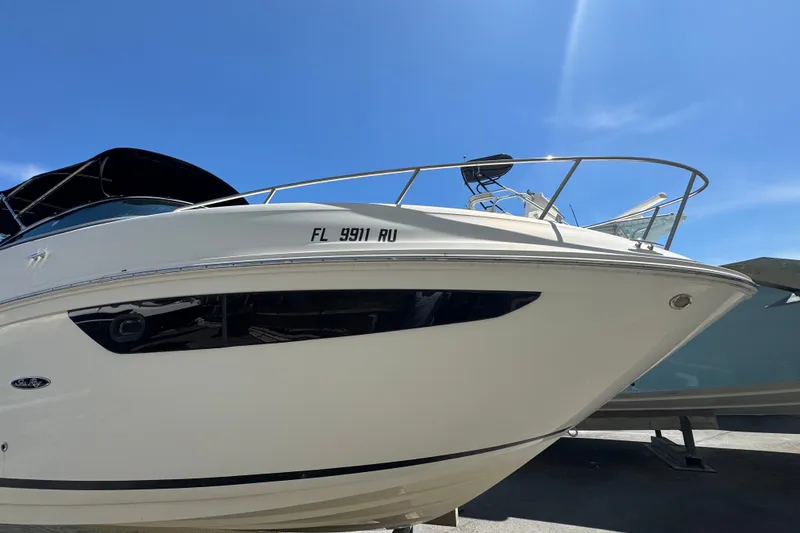 Slide: The Image of 2018 Sea Ray Sundancer 260 boat with sleek design under clear blue sky. - 2