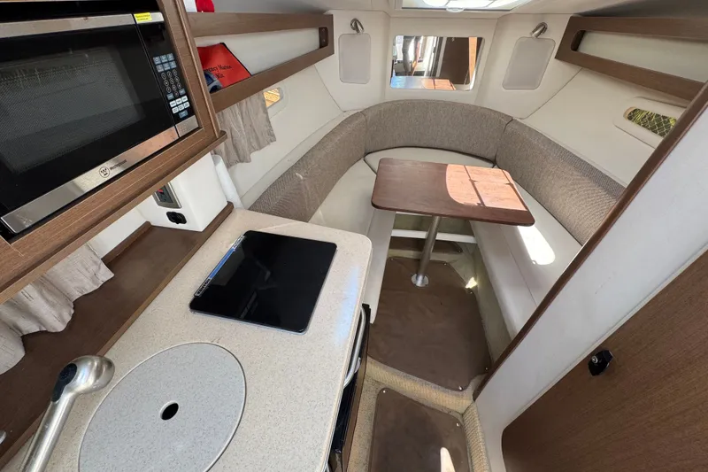 Slide: The Image of 2018 Sea Ray Sundancer 260 cabin interior with kitchenette and seating area. - 40