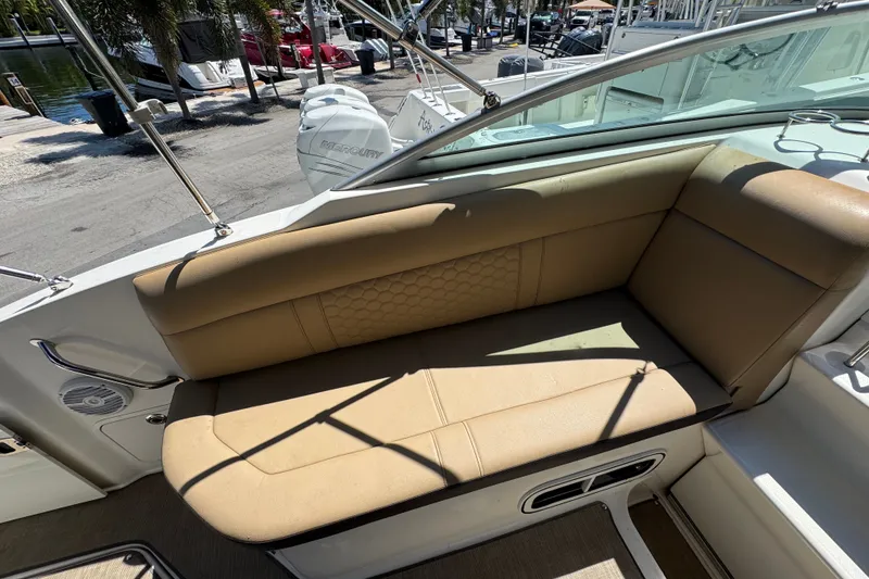 Slide: The Image of 2018 Sea Ray Sundancer 260 boat interior with tan seating and outdoor view. - 29