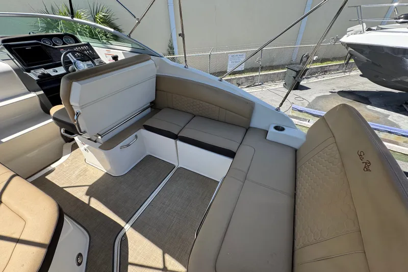 Slide: The Image of 2018 Sea Ray Sundancer 260 interior with beige seating and modern dashboard. - 24