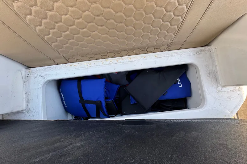 Slide: The Image of Storage compartment on a 2018 Sea Ray Sundancer 260 with life jackets inside. - 50