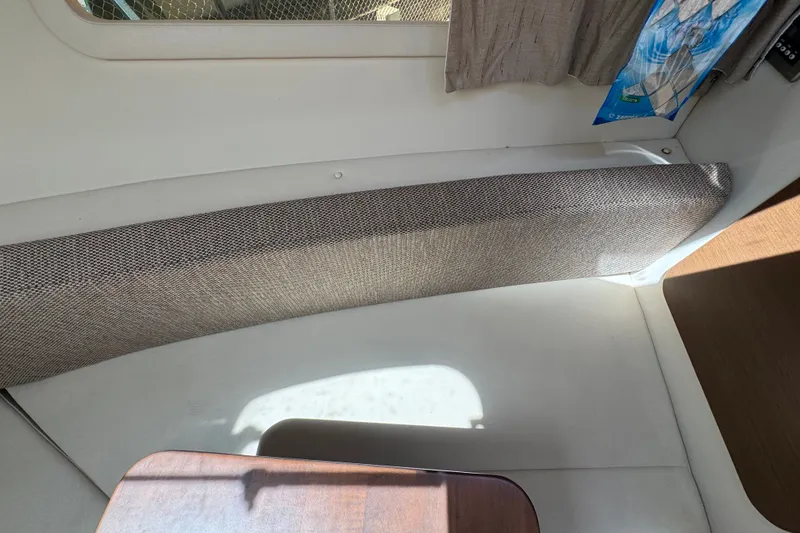 Slide: The Image of Interior of a 2018 Sea Ray Sundancer 260 boat, featuring seating and a wooden table. - 76
