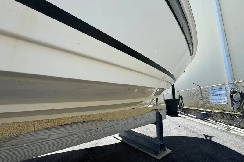 Slide: The Image of 2018 Sea Ray Sundancer 260 boat hull on a support stand, outdoor storage area. - 13