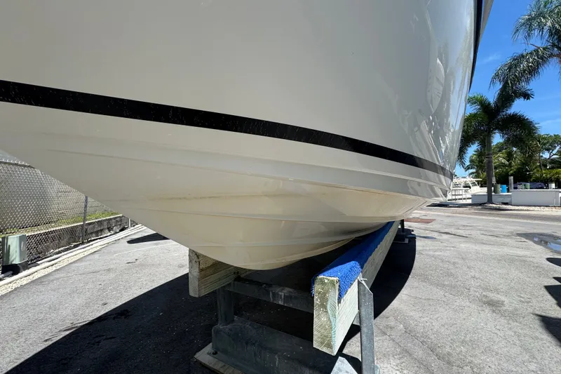 Slide: The Image of 2018 Sea Ray Sundancer 260 boat hull on a trailer, parked outdoors. - 10