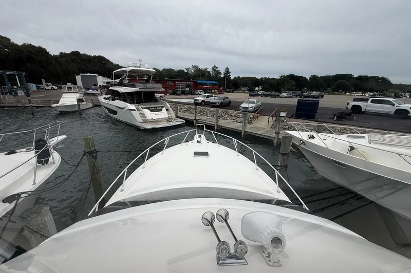 Slide: The Image of 2003 Ocean Yachts 43 Super Sport docked at marina with other boats and vehicles nearby. - 4