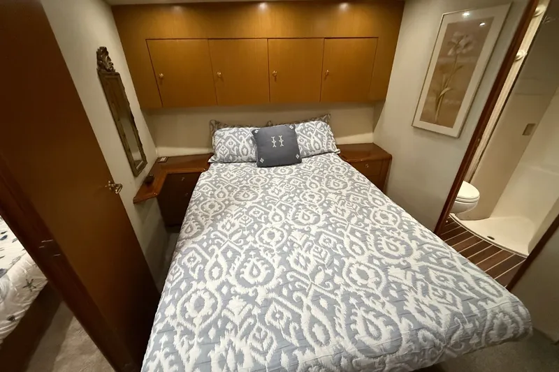 Slide: The Image of Cozy bedroom in 2003 Ocean Yachts 43 Super Sport with patterned bedding and wooden cabinets. - 21