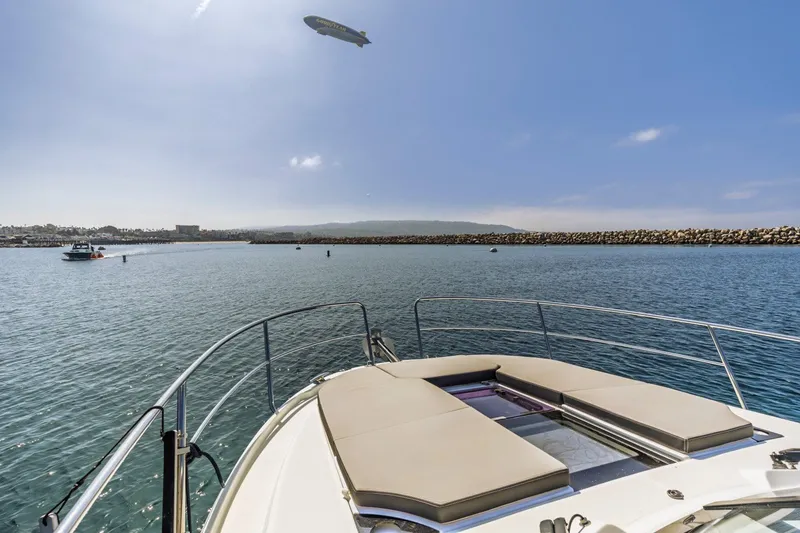 Slide: The Image of 2020 Jeanneau NC 1095 yacht on calm water with blimp overhead. - 18