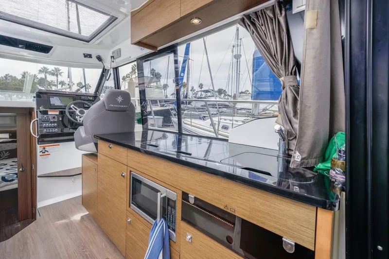 Slide: The Image of Interior of 2020 Jeanneau NC 1095 boat with helm and kitchenette area. - 23