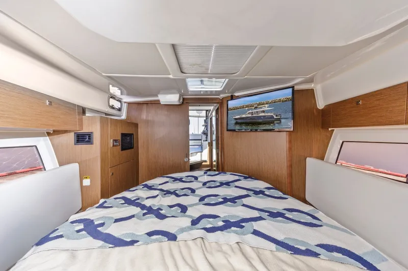 Slide: The Image of Interior of 2020 Jeanneau NC 1095 boat cabin with bed and TV. - 32