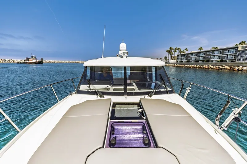 Slide: The Image of 2020 Jeanneau NC 1095 boat cruising in a sunny marina with clear blue skies. - 19
