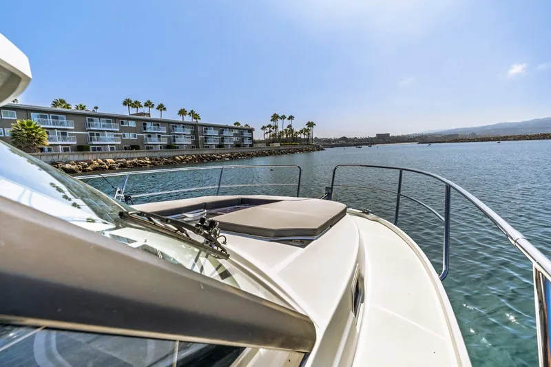 Slide: The Image of 2020 Jeanneau NC 1095 boat cruising near waterfront buildings and palm trees. - 17