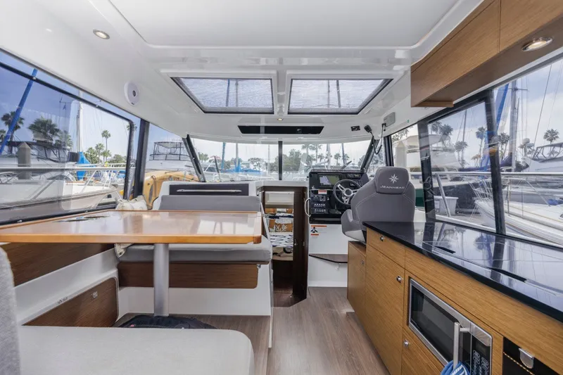 Slide: The Image of Interior of 2020 Jeanneau NC 1095 boat with modern seating and navigation area. - 21