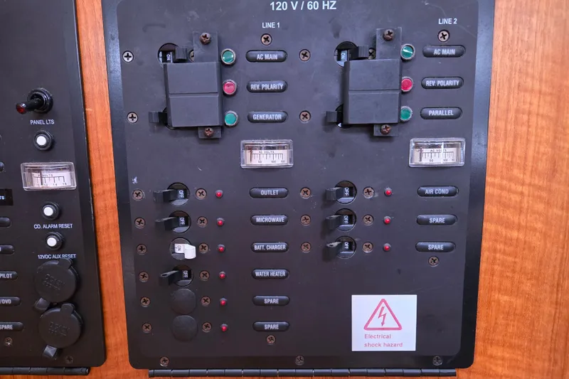 Slide: The Image of Electrical control panel on a 2006 Hunter 36 boat, featuring switches and voltage meters. - 21