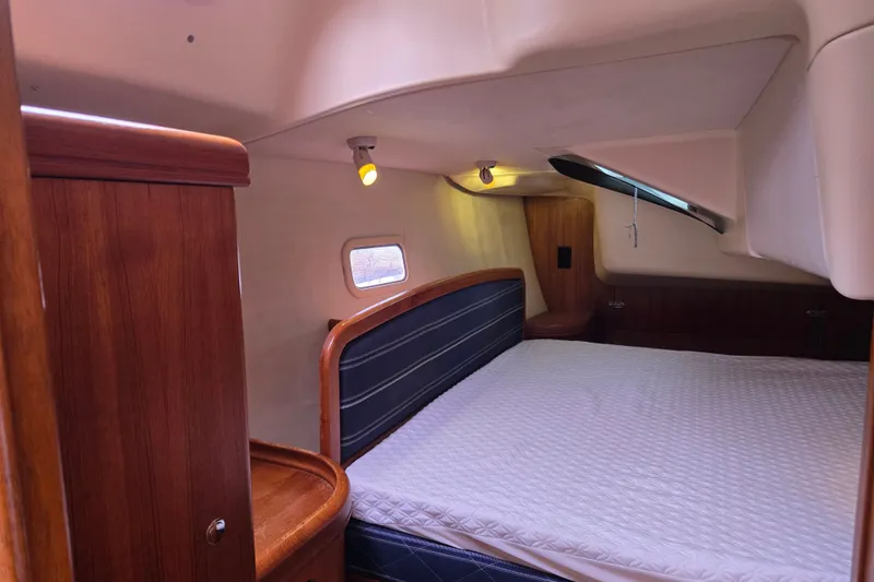 Slide: The Image of Cozy cabin interior of 2006 Hunter 36 sailboat with wooden furnishings and bed. - 31