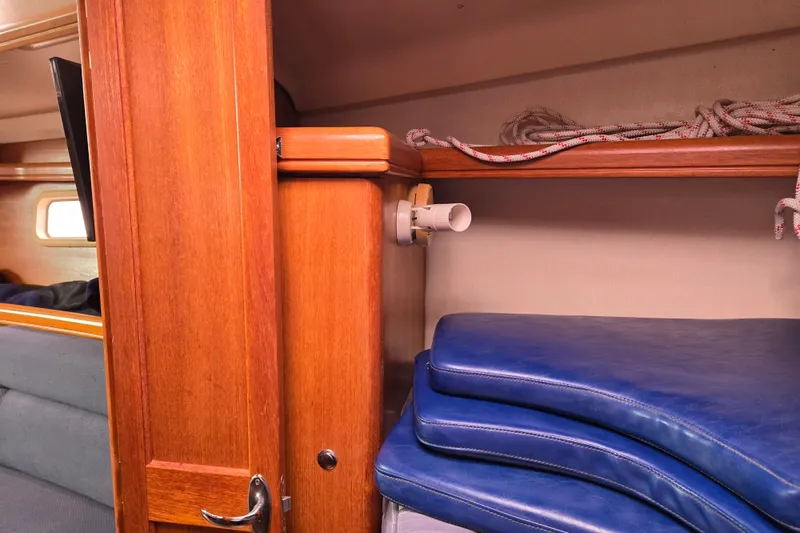 Slide: The Image of Interior of a 2006 Hunter 36 sailboat with wooden cabinetry and blue cushions. - 17