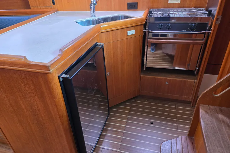 Slide: The Image of Compact kitchen area in a 2006 Hunter 36 sailboat with stove, sink, and fridge. - 25