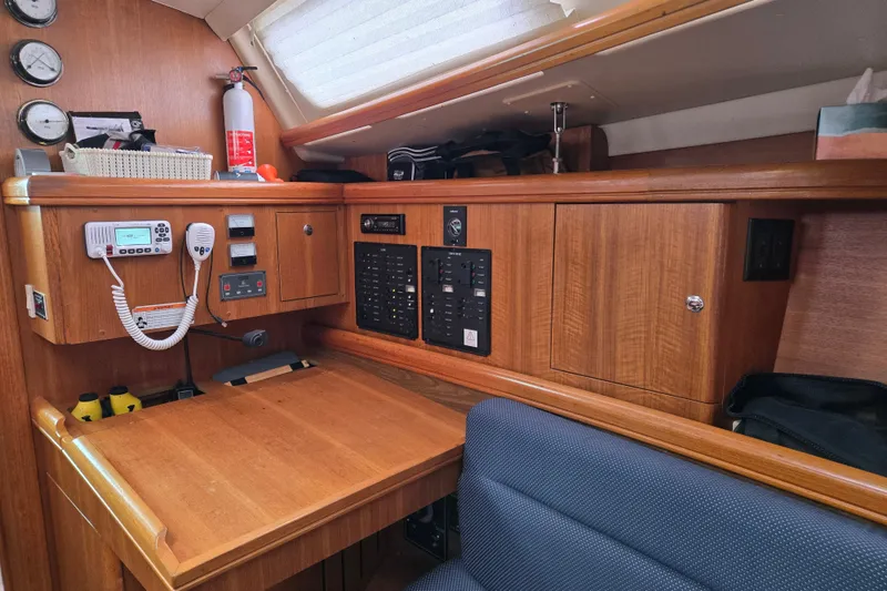 Slide: The Image of Navigation station inside a 2006 Hunter 36 sailboat, featuring wood cabinetry and communication equipment. - 18