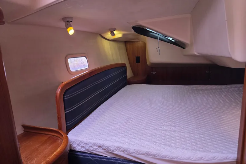 Slide: The Image of Cozy cabin interior of 2006 Hunter 36 sailboat with bed and wooden accents. - 32