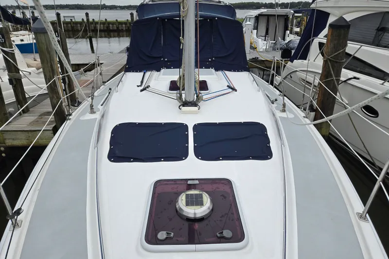 Slide: The Image of 2006 Hunter 36 sailboat docked, featuring a clean deck and covered hatches. - 5