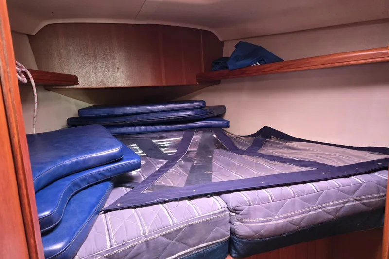 Slide: The Image of Interior cabin of a 2006 Hunter 36 sailboat with blue cushions and storage shelves. - 15