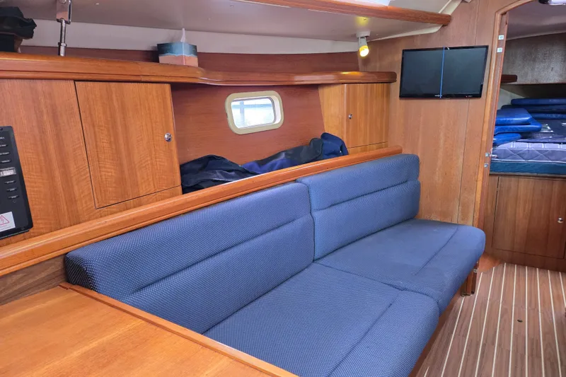 Slide: The Image of Interior of 2006 Hunter 36 sailboat with blue seating and wooden cabinetry. - 12