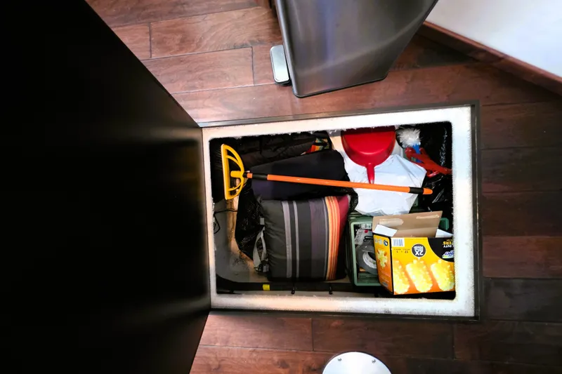 Slide: The Image of Storage compartment on 2012 Sea Ray 410 Sundancer with cleaning supplies and tools. - 30