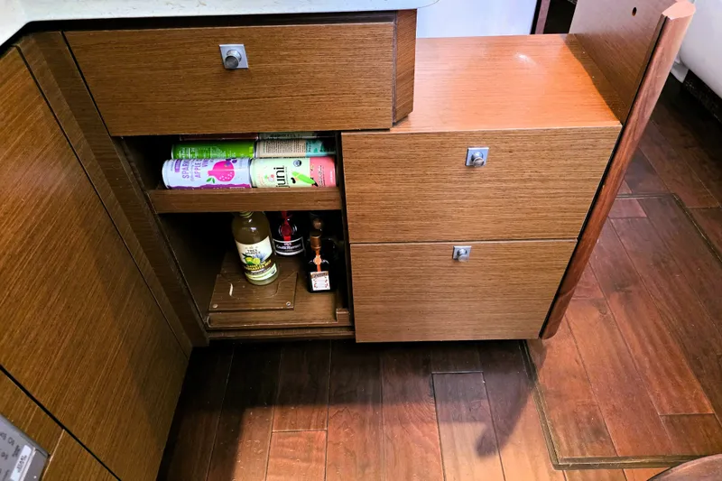 Slide: The Image of Wooden cabinet with open shelves, storing beverages, inside a 2012 Sea Ray 410 Sundancer yacht. - 19