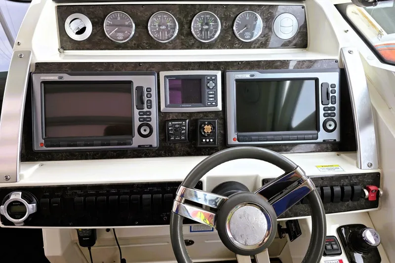 Slide: The Image of Control panel of a 2012 Sea Ray 410 Sundancer boat with navigation screens and gauges. - 12