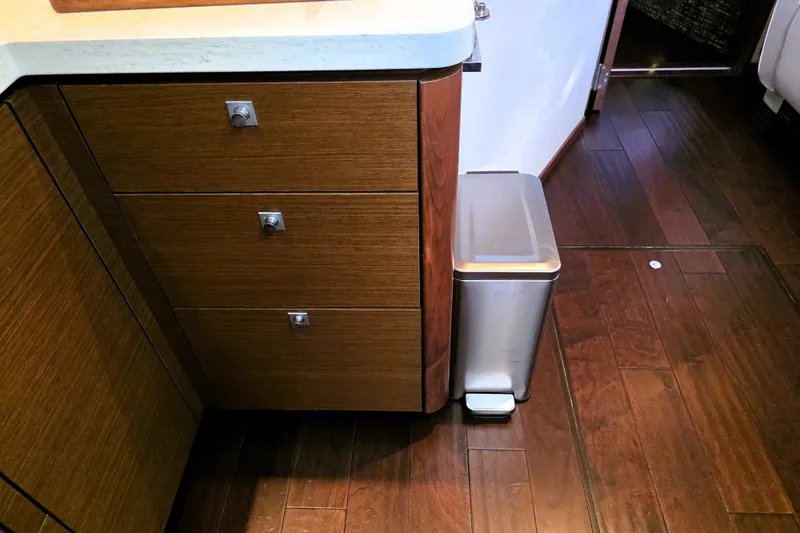 Slide: The Image of Modern kitchen area in 2012 Sea Ray 410 Sundancer with wooden cabinets and stainless steel trash bin. - 20