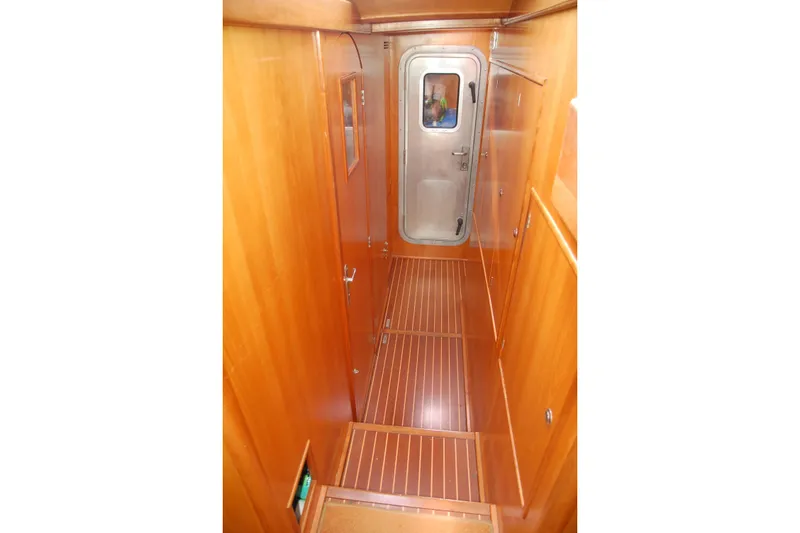 Slide: The Image of Wood-paneled hallway inside 2000 Garcia 48 Raised Salon yacht, featuring a metal door. - 62