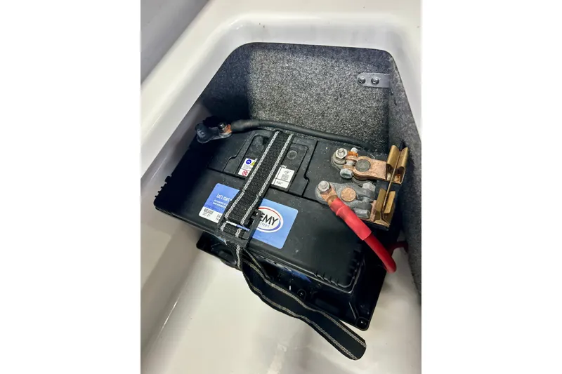 Slide: The Image of Battery compartment of a 2022 Scarab 215 ID boat, featuring secure connections. - 58