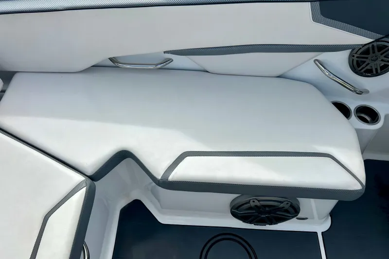 Slide: The Image of 2022 Scarab 215 ID boat interior with white cushioned seating and speaker system. - 21