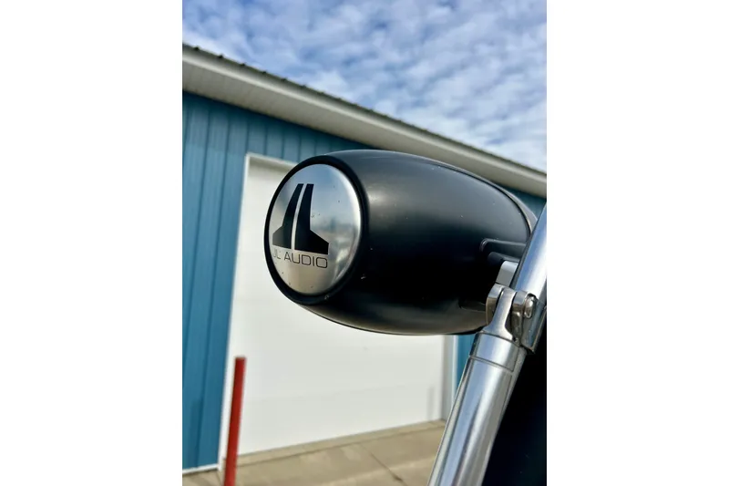 Slide: The Image of Close-up of JL Audio speaker on 2022 Scarab 215 ID boat, blue building background. - 52