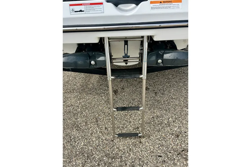 Slide: The Image of Rear view of 2022 Scarab 215 ID boat with extended metal ladder. - 19