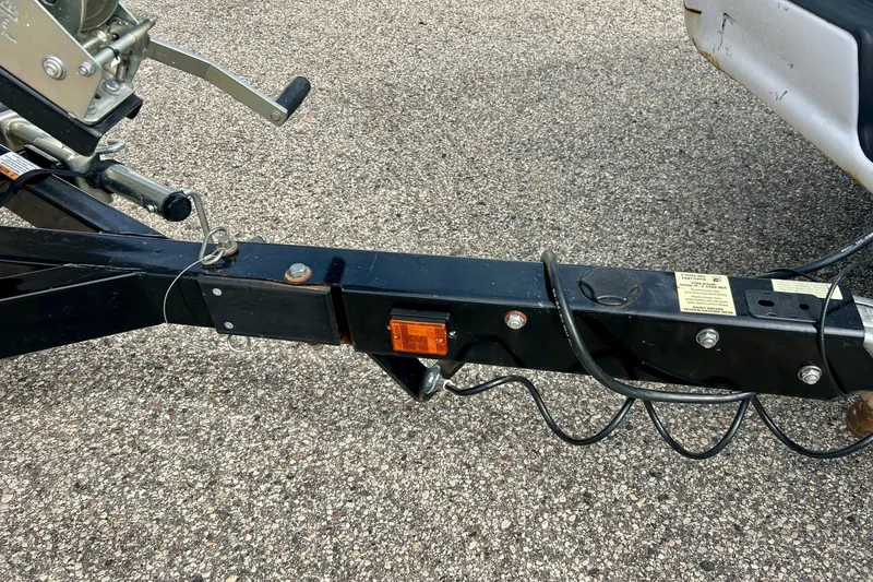 Slide: The Image of Trailer hitch of a 2022 Scarab 215 ID on a textured pavement background. - 62