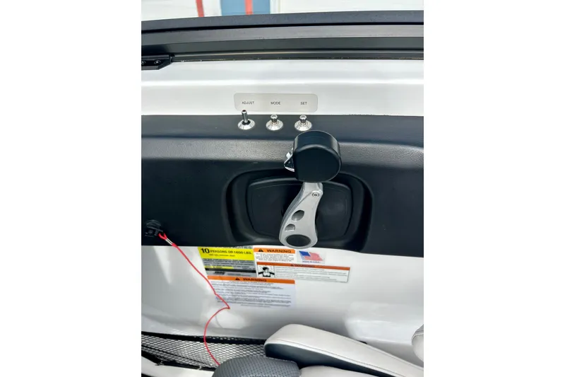 Slide: The Image of Interior controls of a 2022 Scarab 215 ID boat, featuring adjustment switches and a throttle lever. - 28