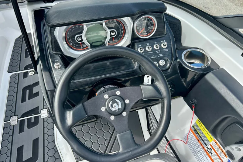 Slide: The Image of Cockpit view of 2022 Scarab 215 ID boat with steering wheel and dashboard controls. - 26