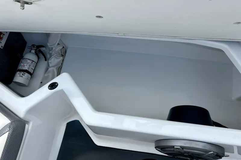 Slide: The Image of 2022 Scarab 215 ID boat storage compartment with fire extinguisher. - 22