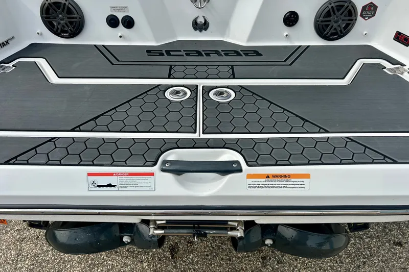 Slide: The Image of 2022 Scarab 215 ID boat stern with hexagonal pattern and warning labels. - 16