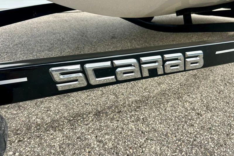 Slide: The Image of Scarab 215 ID 2022 model logo on a black surface. - 64
