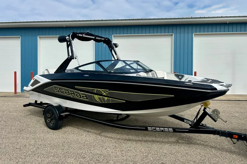 The Image of 2022 Scarab 215 ID boat on trailer, parked outside blue garage doors. - 0
