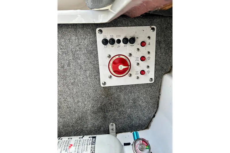 Slide: The Image of Control panel of a 2022 Scarab 215 ID boat with switches and fire extinguisher. - 23