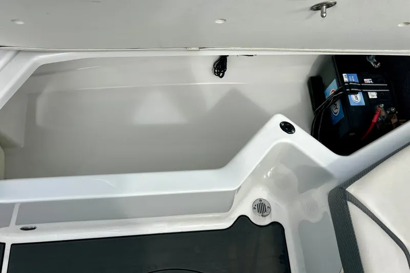 Slide: The Image of 2022 Scarab 215 ID boat storage compartment with battery and drainage system. - 25