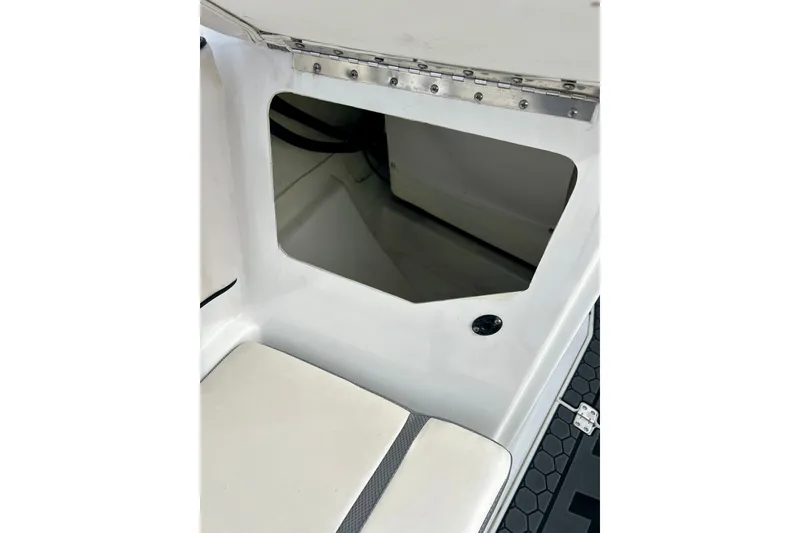 Slide: The Image of 2022 Scarab 215 ID boat storage compartment with open hatch and cushioned seating. - 57