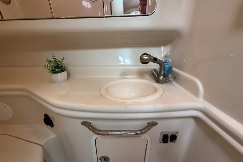Slide: The Image of Bathroom sink area in 2006 Sea Ray Sundancer 320 yacht, featuring faucet and small plant. - 47
