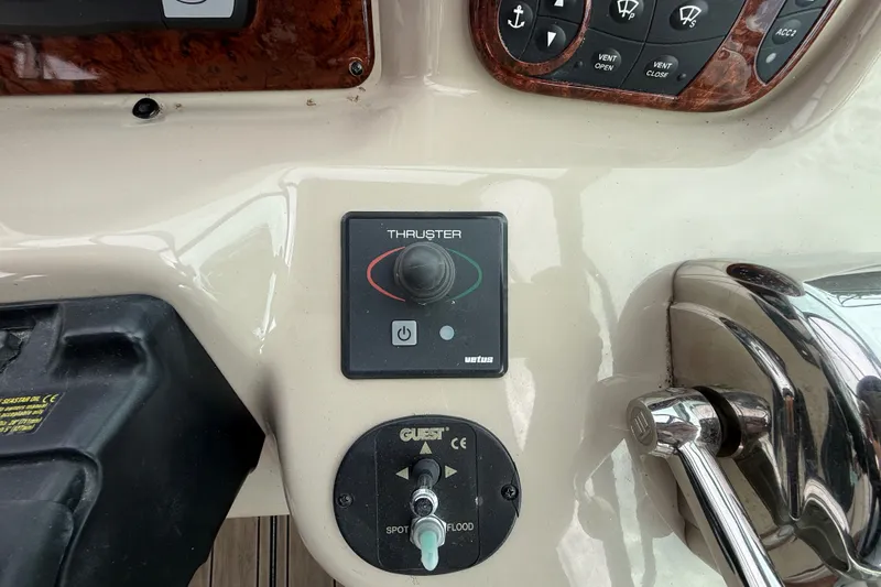 Slide: The Image of Control panel of a 2006 Sea Ray Sundancer 320 boat, featuring thruster and spotlight controls. - 20