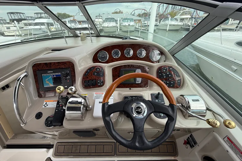 Slide: The Image of Cockpit view of a 2006 Sea Ray Sundancer 320, featuring steering wheel and control panel. - 18